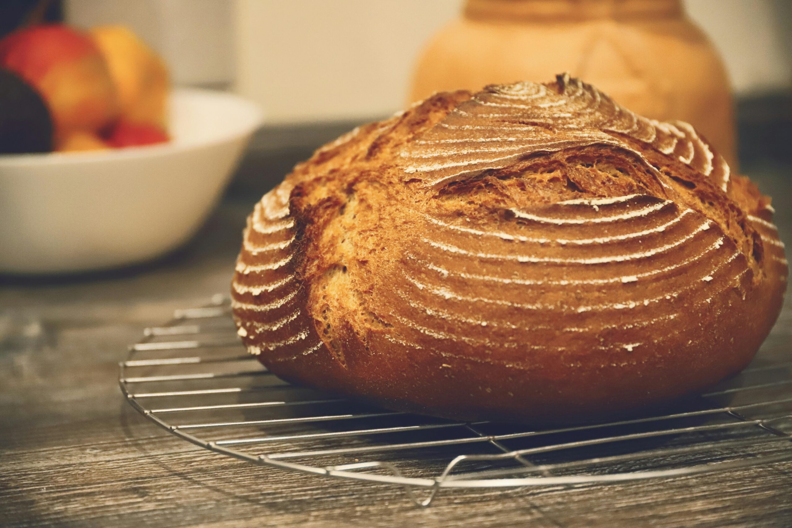 Freshly baked rye bread cooling on a rack indoors, showcasing a rustic artisanal crust.